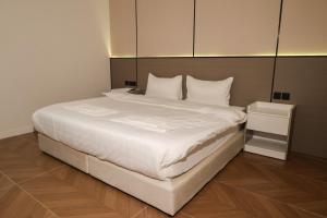 a bed with white sheets and pillows in a room at رست للشقق المخدومة in Medina