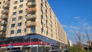 a tall building on a street with cars parked in front at Przestronny Apartament typu Studio, GARAŻ W CENIE in Wrocław