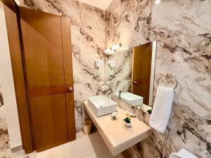 a bathroom with a sink and a mirror at Shelton Rezidor House F-8 Islamabad in Islamabad +31 photos