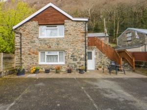 a stone house with a patio in front of it at First Floor Apartment in Porthmadog