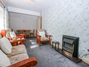 a living room with a fireplace and a table at First Floor Apartment in Porthmadog