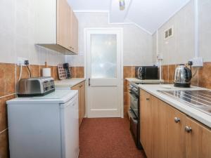 a small kitchen with a refrigerator and a sink at First Floor Apartment in Porthmadog
