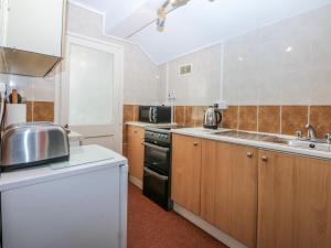 a kitchen with a sink and a stove at First Floor Apartment in Porthmadog +13 photos