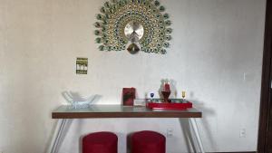 a dressing table with red chairs and a mirror on the wall at Hospedagem no Farol da Barra in Salvador