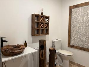 a bathroom with a toilet and a wooden window at La bergerie des petits loups in Montagnac-la-Crempse