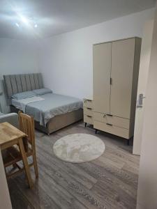 a bedroom with two beds and a cabinet and a table at Rose Acre Home Basildon in Basildon