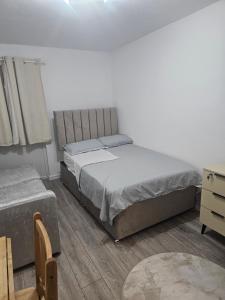 a bedroom with a bed and a dresser at Rose Acre Home Basildon in Basildon