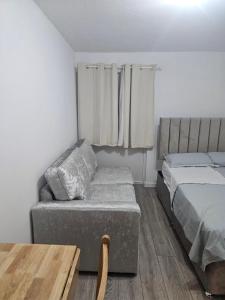 a bedroom with a bed and a couch and a table at Rose Acre Home Basildon in Basildon +18 photos