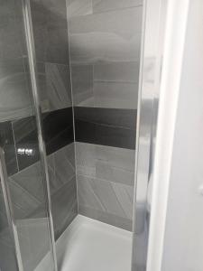 a walk in shower with a glass door at Rose Acre Home Basildon in Basildon