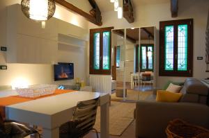 Il dispose d'une cuisine et d'un salon avec un canapé et une table. dans l'établissement Loft Due Cuori con terrazza, à Venise