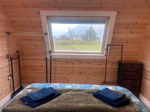 a bedroom with a bed in a room with a window at Dalrigh Pod 2 in Onich