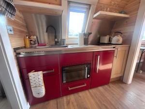 a kitchen with a red stove and a sink at Dalrigh Pod 2 in Onich