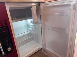 an empty refrigerator with its door open in a kitchen at Dalrigh Pod 2 in Onich