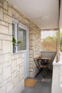 a patio with a stone wall and a window at Apartma Licko in Domžale