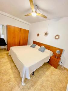 a bedroom with a bed with a ceiling fan at Alma Marina Alcossebre - WiFi - Pet friendly - Aire Acondicionado in Alcossebre