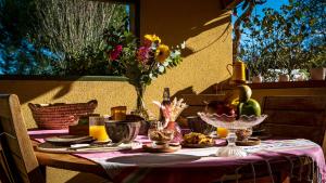 a table with a purple table cloth with fruit on it at Chambre Terracotta privée et accès jacuzzi - sauna in Lézat-sur-Lèze
