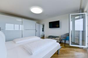 a white bedroom with two beds and a window at Am Sahlenburger Strand AS23 in Cuxhaven +23 photos