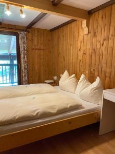a large bed in a room with wooden walls at Fichtenblockhütte in Sonnenalpe Nassfeld