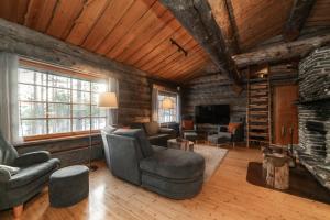 a living room with a couch and a fireplace at Villa Poronperä in Kuusamo