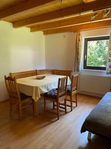 a dining room with a table and chairs and a window at Fichtenblockhütte in Sonnenalpe Nassfeld