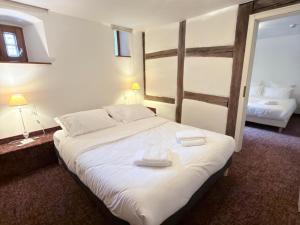 a bedroom with a large bed with two towels on it at Hôtel Le Sarment d'Or in Riquewihr +17 photos