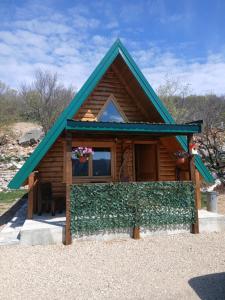 a small log cabin with a green roof at Lake house angela in Kuside +20 photos