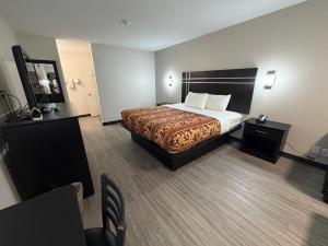 a hotel room with a bed and a chair at Sunset Inn in Brady