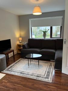 a living room with a black couch and a table at TownHouse Leenane in Leenaun
