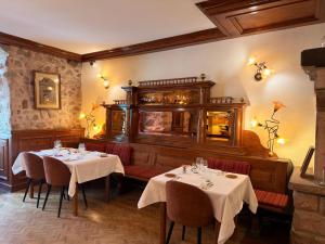 a restaurant with two tables with white table cloth at Hôtel Le Sarment d'Or in Riquewihr