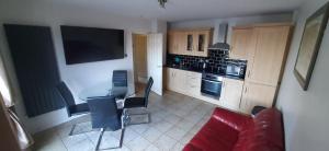 a living room with a table and a kitchen at Ocean Bliss in Bundoran