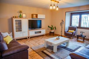 a living room with a couch and a tv at O rincón de Agrón in Melide