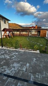 a backyard with a picnic table and a house at Cazare Vila GOG - Rm Valcea-Salina Ocnele Mari- Motorcycle-friendly accommodation in Râmnicu Vâlcea