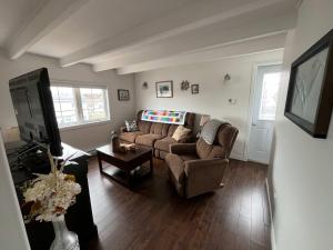 a living room with a couch and a tv at Salty B'y & Nook in Twillingate