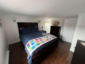 a bedroom with a bed with a colorful quilt on it at Salty B'y & Nook in Twillingate +14 photos