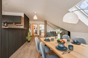 a dining room and kitchen with a wooden table and chairs at FeWo Dock12C in Kölpinsee