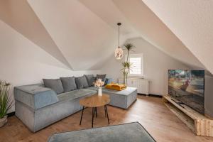a living room with a couch and a tv at FeWo Dock12C in Kölpinsee