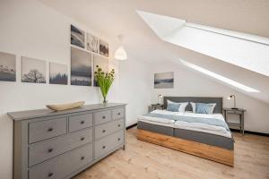 a bedroom with a bed and a dresser in a room at FeWo Dock12C in Kölpinsee