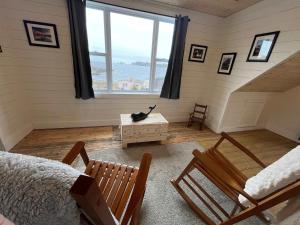 a room with a bed and chairs and a large window at Wild Cove Retreat in Twillingate