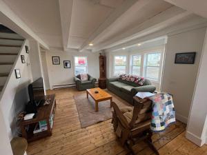 a living room with a couch and a table at Wild Cove Retreat in Twillingate +32 photos