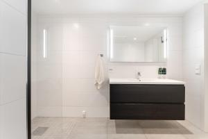 a white bathroom with a sink and a mirror at Aurora Apartments - Stryn View in Stryn +26 photos