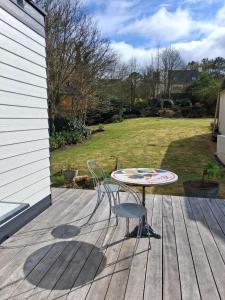 a table and chairs sitting on a deck at Independent studio in Pont-lʼAbbé +1 photo
