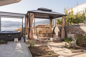 a gazebo with a table and chairs under it at Mihail Residence - Old Town of Kavala in Kavála