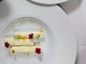 a white plate with three pieces of food on it at Hôtel Le Sarment d'Or in Riquewihr
