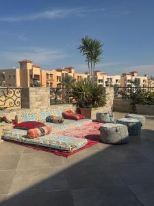 a group of pillows laying on the ground with buildings at black tiger villa in ‘Ezbet `Abd el-Ḥamîd