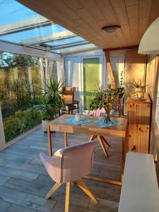 a screened in porch with a wooden table and chairs at Haus Elise in Saalfeld