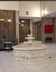 a large fountain in the middle of a lobby at company petty bark شركة بيتي بارك للشقق المخدومة درجة اقصادية in Qarār