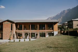 a large brick house with a large yard at Green Sheep Boutique Hotel in Kazbegi