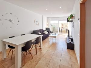 a kitchen and living room with a white table and chairs at Somnis del Delta, Apartamento Deltebre, Delta Ebro in Deltebre