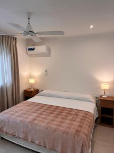 a bedroom with a bed and a ceiling fan at Casa Iturraspe in Reconquista +12 photos