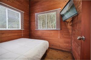 a bedroom with a bed and a flat screen tv at Cabañas La Silleta in Santa Elena